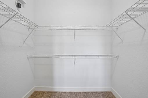 A white wall with a metal rack on top.