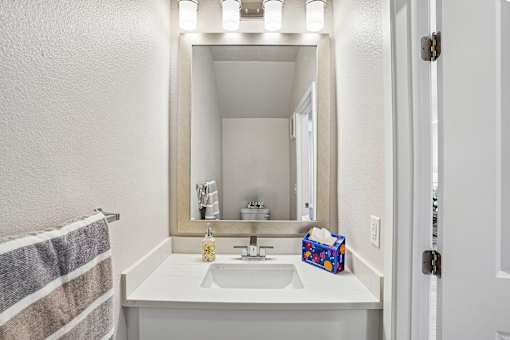 A bathroom with a white sink and a mirror above it.