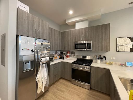 A modern kitchen with a refrigerator, oven, and microwave.