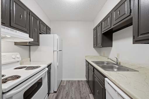 A kitchen with white appliances and dark wood cabinets.