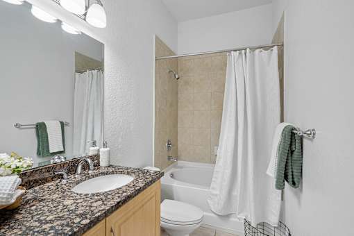 A bathroom with a sink, toilet, and bathtub.
