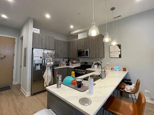 A kitchen with a white counter top and a refrigerator.