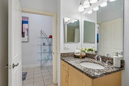 A bathroom with a sink, mirror, and shower.