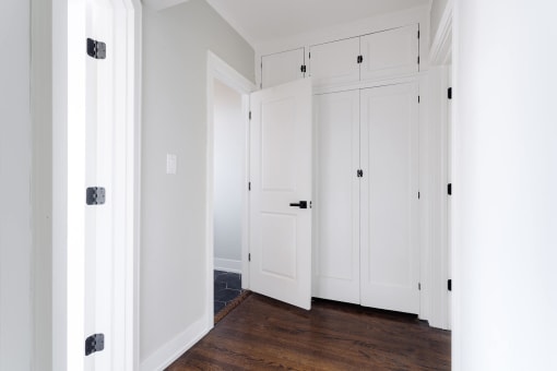a row of white closets in a room with wood floors