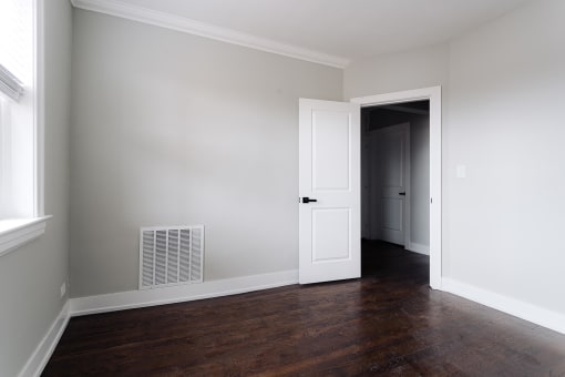 a living room with wood floors and a white door
