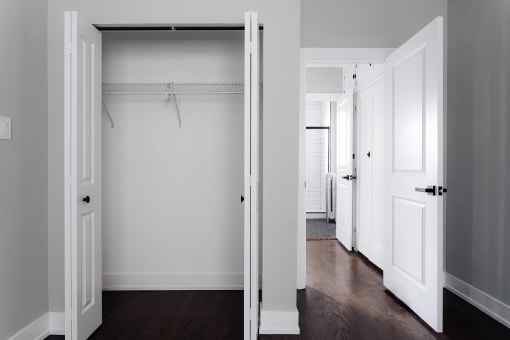 a bedroom with white walls and a closet with white doors