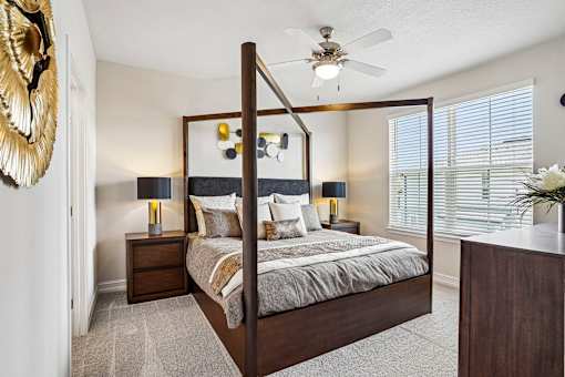 A bedroom with a large bed and a ceiling fan.