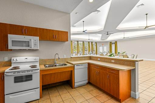 A kitchen with a white stove and a white microwave.