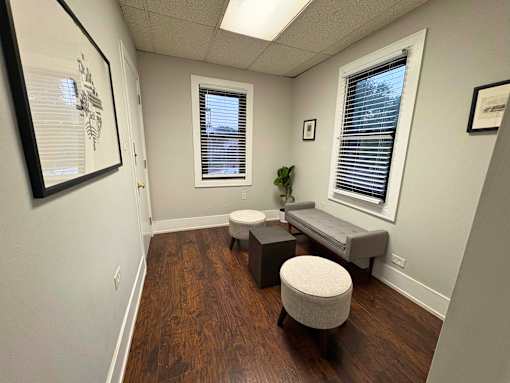 A room with a bench, a toilet, and a plant.