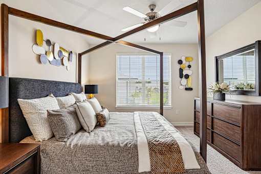 A bedroom with a bed, nightstand, and a ceiling fan.