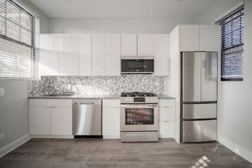 a kitchen with white cabinets and stainless steel appliances