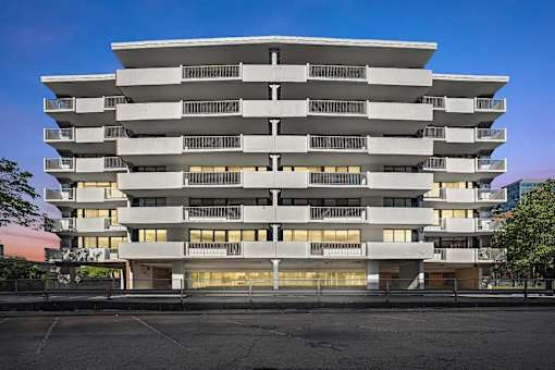 A large white building with many windows and balconies.