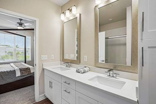 A bathroom with a large mirror and a window.