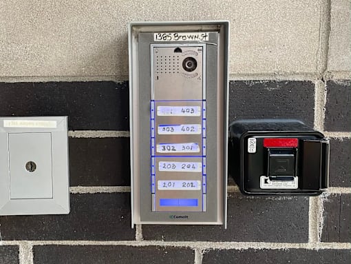 A brick wall with a meter and a switch.