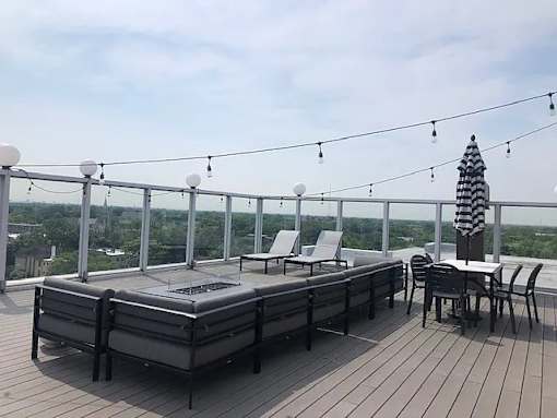 A deck with a table and chairs overlooking a cityscape.