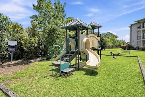 A playground with a green slide and a yellow slide.