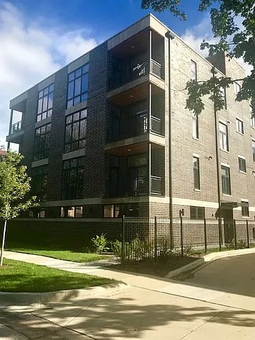 A modern brick building with a balcony on the second floor.