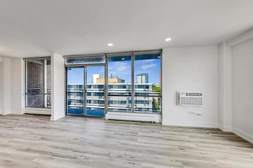 A room with a large window and a wooden floor.