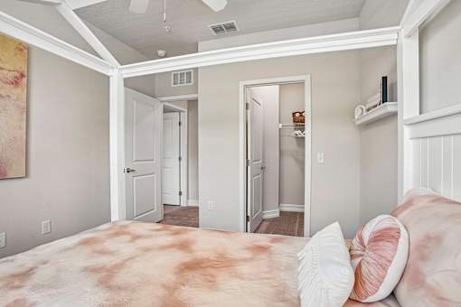 A bedroom with a large bed and a ceiling fan.