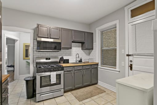 a kitchen with stainless steel appliances and gray cabinets
