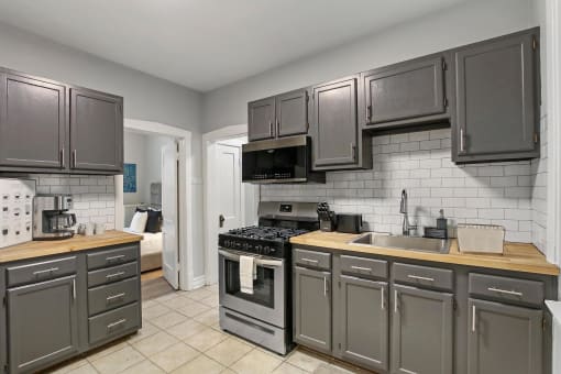 a kitchen with stainless steel appliances and gray cabinets
