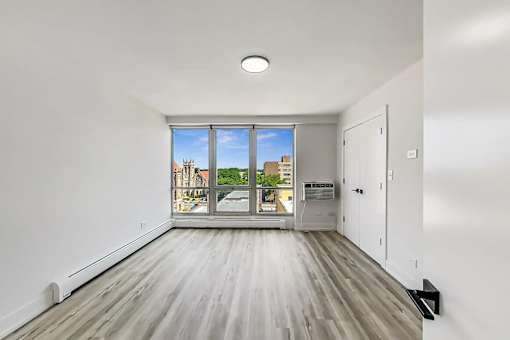 A spacious room with a view of the city through the window.