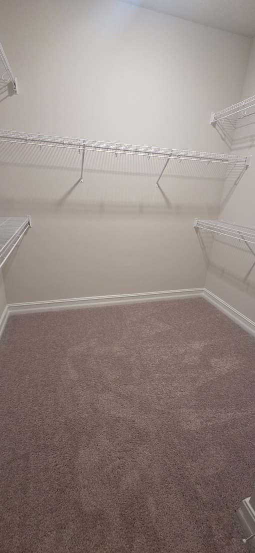 Empty room with carpeted floor and white walls.