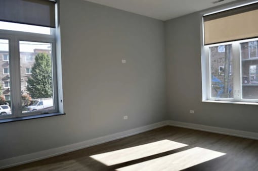 A room with a large window and a view of a building across the street.