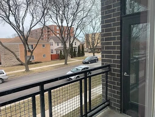 A black metal fence in front of a brick building.