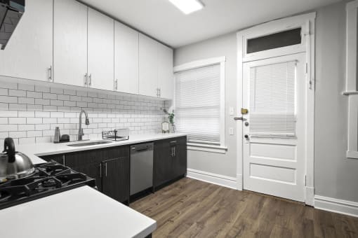 a kitchen with white cabinets and a white door