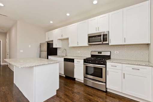 A kitchen with white cabinets and stainless steel appliances.