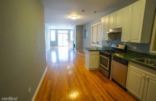 an empty kitchen and living room with a wood floor