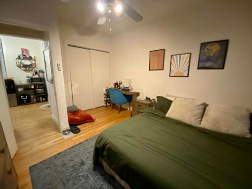 A bedroom with a bed, desk, and chair.