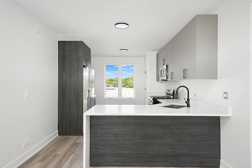 A modern kitchen with a large island and a view of the outdoors.