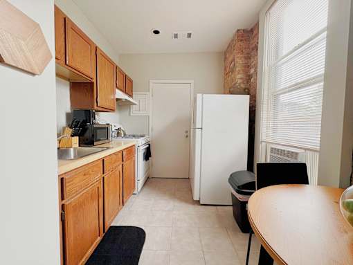 A kitchen with wooden cabinets and a white refrigerator.