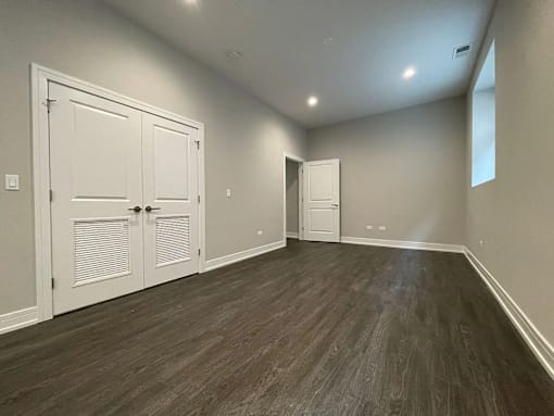 A room with wood flooring and white doors.