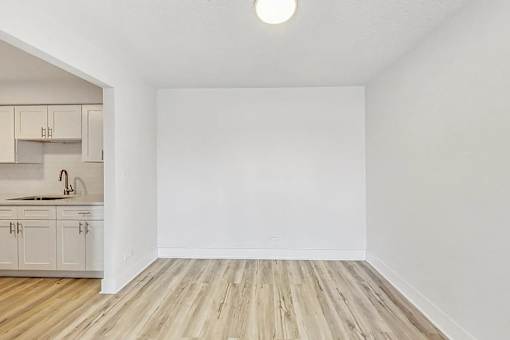 A kitchen with wooden floors and white walls.