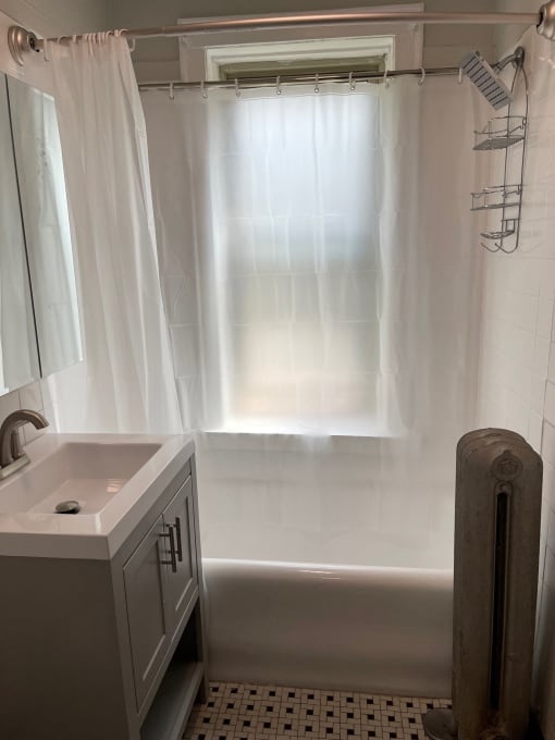 a bathroom with a sink and a tub and a shower curtain