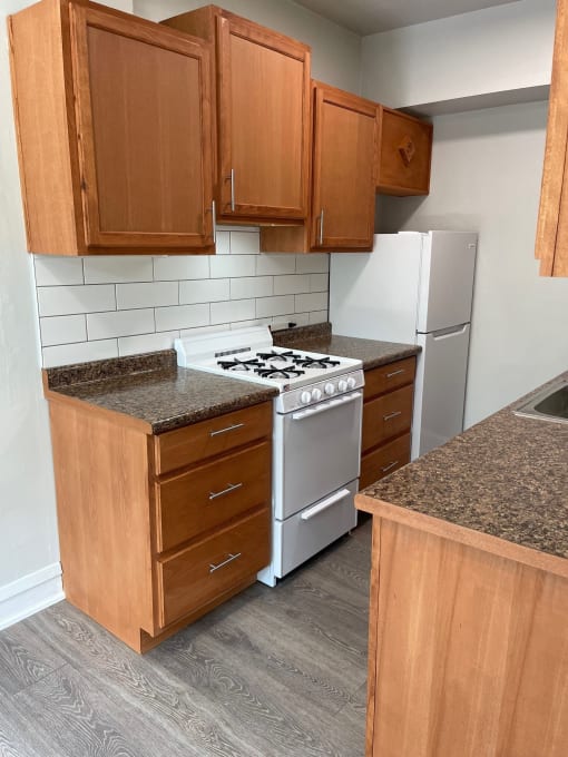 an empty kitchen with wooden cabinets and a stove and refrigerator