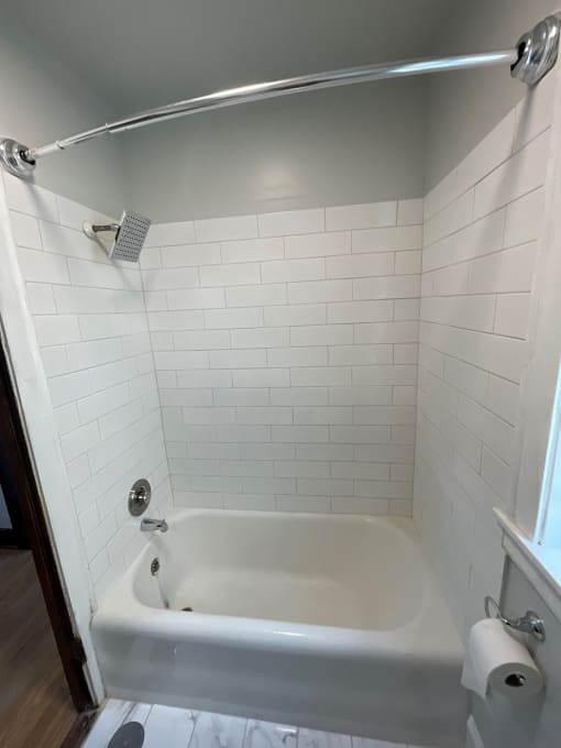 a white bathroom with a tub and a shower curtain