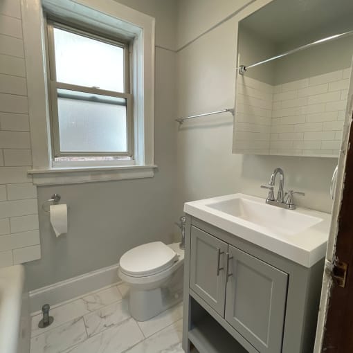 a small bathroom with a sink toilet and a window
