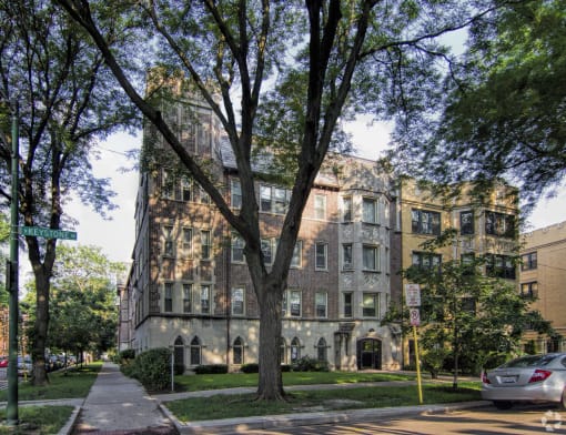 an apartment building on a city street with trees
