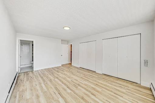 A room with wooden flooring and white walls.