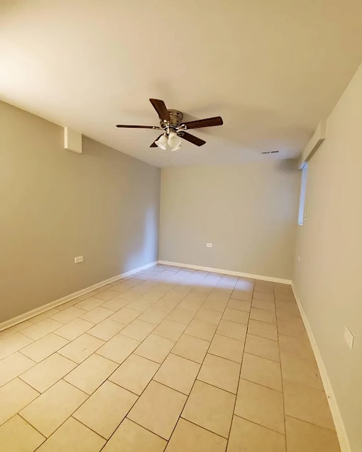 A room with a ceiling fan and tiled floor.