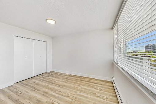 A room with a sliding door and a window with blinds.