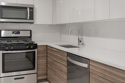 A modern kitchen with a stainless steel dishwasher and microwave above the stove.