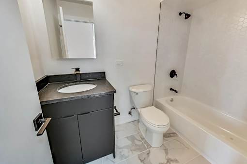 A bathroom with a sink, toilet, and bathtub.