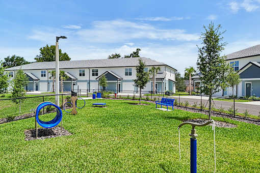 A playground area in front of a building with a blue swing set.