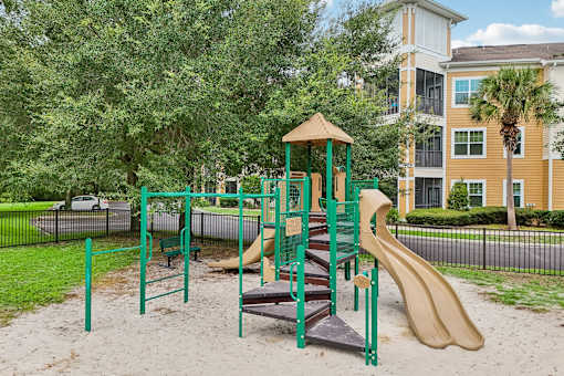 A playground with a green slide and a brown slide.