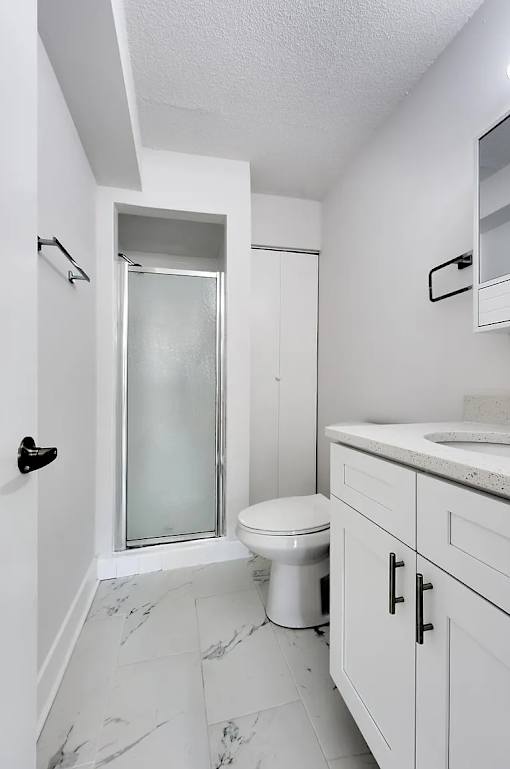 A white toilet in a bathroom with a walk-in shower.